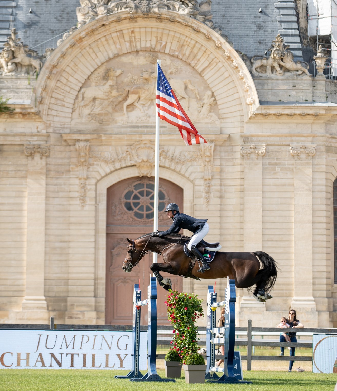 Rider on horse jumping over obstacle